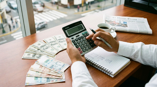 persona calculando el dólar hoy en Perú con una calculadora y billetes de dólares y soles sobre un escritorio