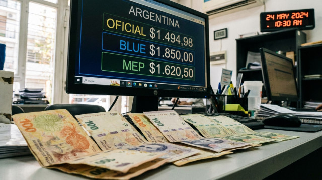 primer plano de billetes argentinos y un monitor con cotizaciones del dólar, enfoque en una pantalla que muestre la palabra 'Argentina' y números de cotización