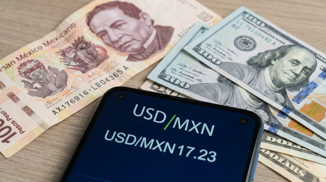 Billetes de peso mexicano y billetes de dólar americano sobre una superficie neutra con una pantalla digital mostrando 'USD/MXN 17.23'